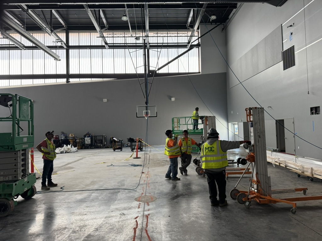 Hoisting and positioning a heavy gym speaker at Burlingame High School